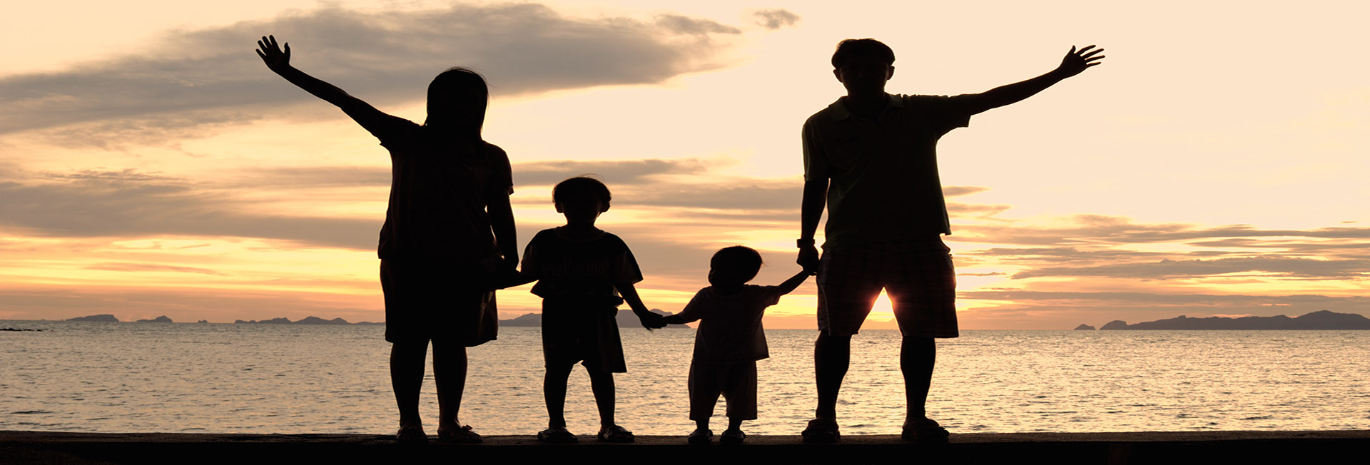 silhouette of family on the beach at dusk.