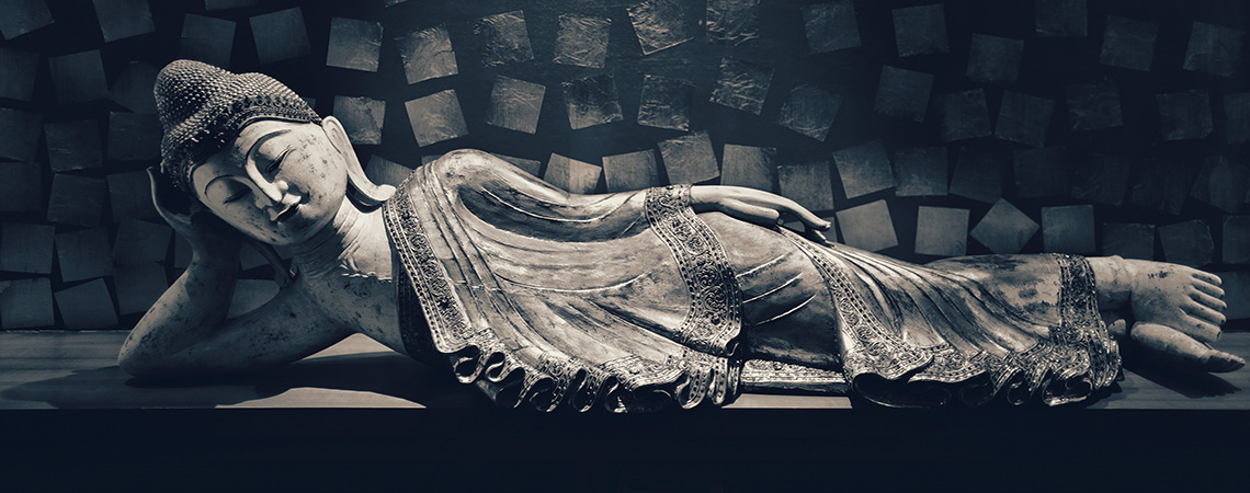 Antique carved wooden Buddha, reclining Buddha posture. selective focus.